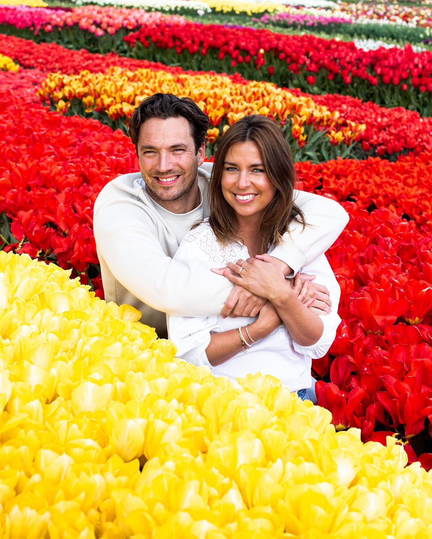 Romantische fotoshoot tussen de kleurrijke tulpen in de Bollenstreek van Noordwijkerhout. Koppel geniet van de schoonheid van rode en gele tulpenvelden. Verken buitenactiviteiten en prachtige landschappen in Nederland.